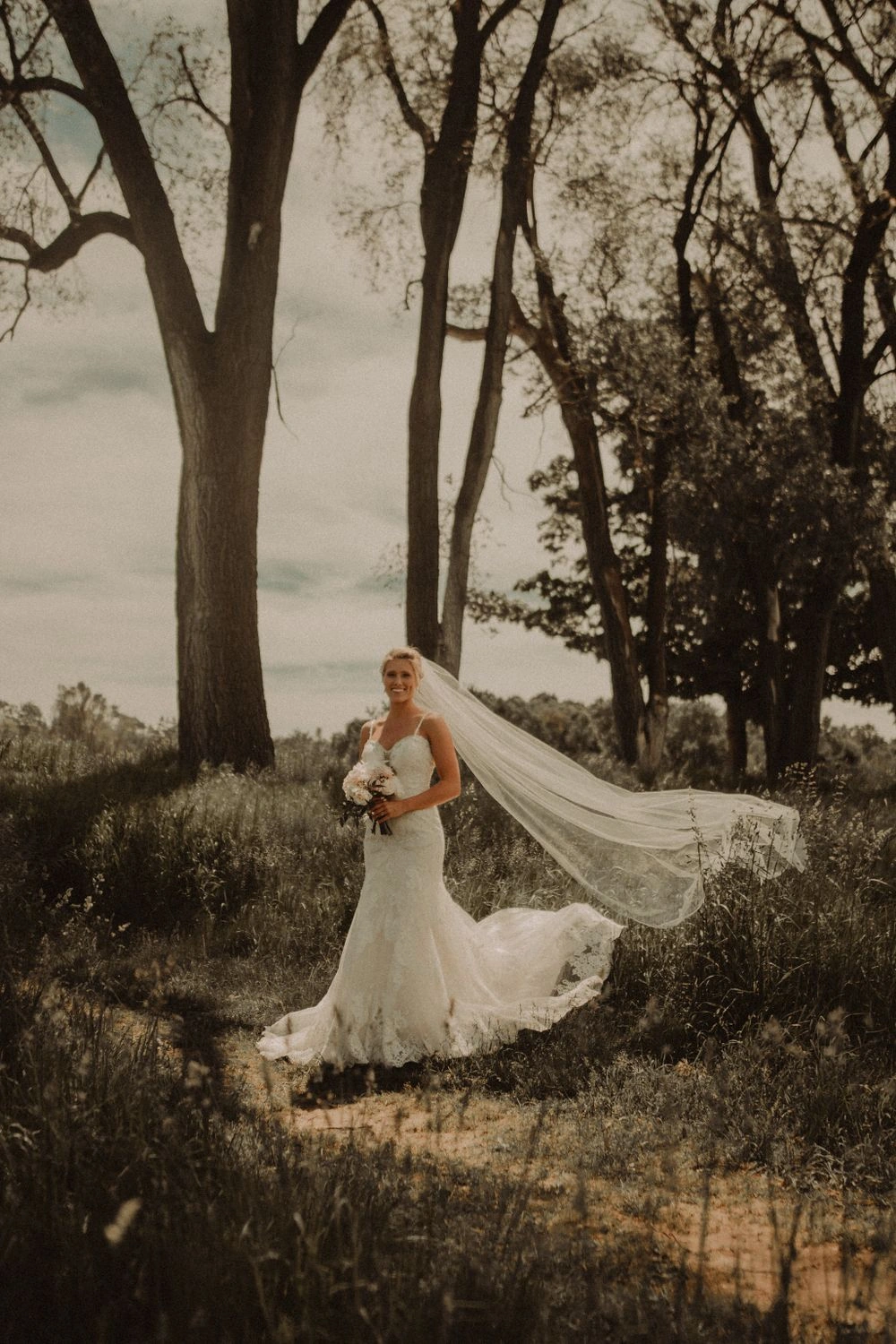 Film-inspired bridal portrait among tall trees